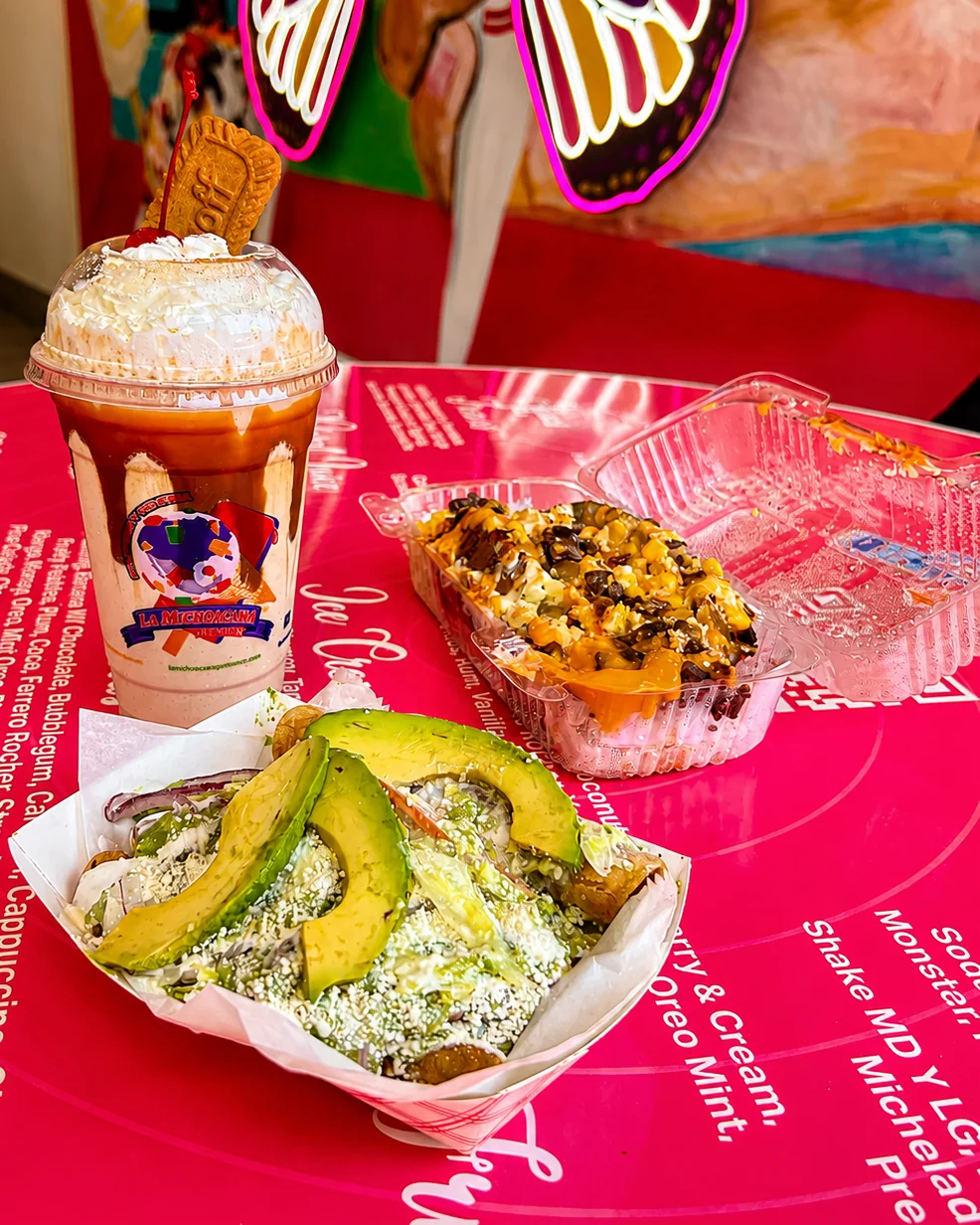 A shake, a prepared corn snack, and a savory dish topped with avocado at La Michoacana Premium Oak Lawn.